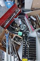 Overhead view of assorted sockets, wrenches, deep socket rails and small parts on table