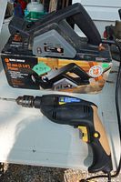 Both power tools showing planer on box and drill