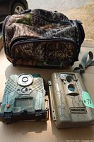 Group shot of both trail cameras and waist pack