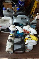 Group of jugs and bottles on table, showing brands and container counts