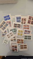 All 24 sealed packs of four-stamp inscription corner blocks spread on table