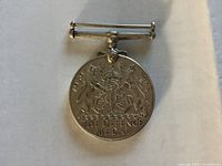 Obverse of Defence Medal showing Royal Arms, dates and inscription, suspension bar visible