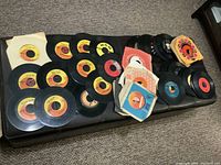 Overview of 45 rpm records spread on ottoman