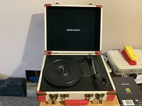 Record player open showing platter, tonearm and Crosley logo