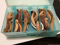 open tackle box showing numerous unfinished wooden lure blanks in compartments