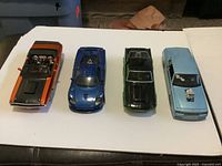 Top view of four die-cast cars showing colours and interiors