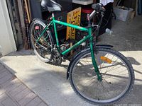 Full view of green Raleigh mountain bike in garage driveway