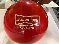 Red bowling ball showing Budweiser logo and serial