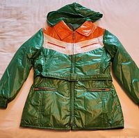 Front view of parka showing color-block design, belt, pockets, hood