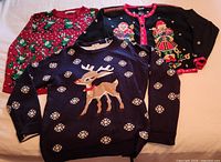Three sweaters laid out showing designs