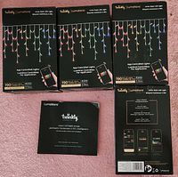 Front view of four boxed Twinkly Luminations sets and manual