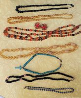 Group shot of all seven necklaces and earrings laid out