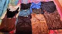 All eleven sleeveless tops laid out showing front view and variety of colours