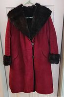 Front view showing burgundy exterior, fur collar, cuffs, buttons, pockets