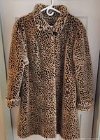 Front view of leopard print faux fur coat on hanger