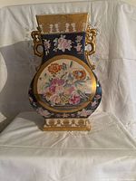 Front view showing floral medallion, gold handles, decorative motifs