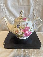 Front view of porcelain teapot with floral design and lid