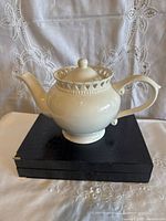 Front view of ivory porcelain teapot on box