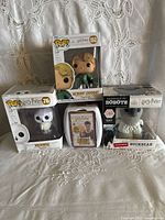 All four boxed items grouped: two Funko Pops, Handmade by Robots Buckbeak, Top Trumps Quiz game