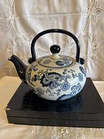 Side view of porcelain teapot showing floral design and handle