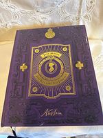 Front cover showing purple embossed design with gold accents and central cameo