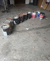 All paint cans lined up on garage floor