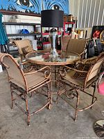 Full patio set showing table, four chairs, lamp, pillows