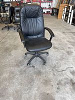 Full view of black faux leather swivel office chair on casters