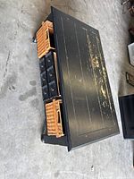 Full view of rectangular black distressed coffee table with baskets and drawers