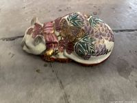 Top view of the hand-painted ceramic sleeping cat figurine showing floral and gilt details
