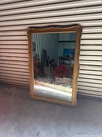 Front view showing mirror glass and scalloped wood frame