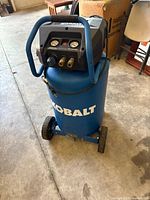 Full view of Kobalt 20-gallon vertical compressor showing tank, handle and wheels