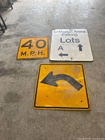 All three metal traffic signs laid out on floor