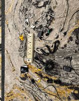 Top-down view of entire assortment of power strip, extension cord, adapters and cables on rug