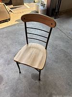 Full view of one metal chair showing frame, seat, and backrest