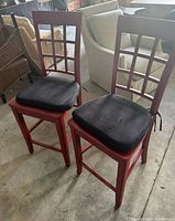 Pair of red wooden bar stools with cushions