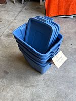 Stack of blue storage totes with lids nested inside