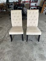 Front view of both beige tufted dining chairs