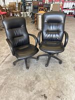 Two black padded office chairs side by side