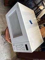 Front and top view of Sharp Carousel white microwave showing control panel and overall exterior condition