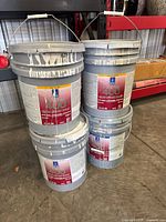 All four pails stacked showing front labels and general condition