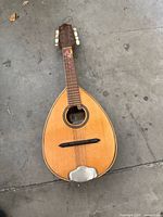 Full view of bandurria front showing teardrop body, bridge, tailpiece, neck, headstock