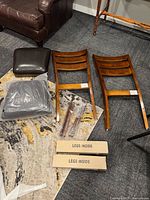 All components of the two side chairs laid out: seat cushions, chair backs/frames, legs packaged, hardware packs