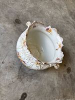 Full view of cachepot showing relief design, floral transfers, scalloped gilt rim