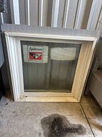 Front view of Andersen double-hung transom window showing frame and AW logo sticker