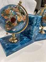 Front view of one bookend showing globe and base