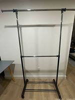 Front view of garment rack showing upper and middle hanging rods