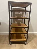 Front view of metal frame shelf with five wood shelves on casters