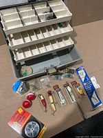 Lot overview with tackle box open, line spool, bobbers, lures, swivel pack and other tackle