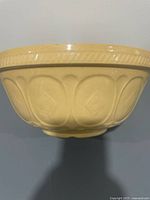 Side view of beige earthenware Gripstand mixing bowl showing relief pattern